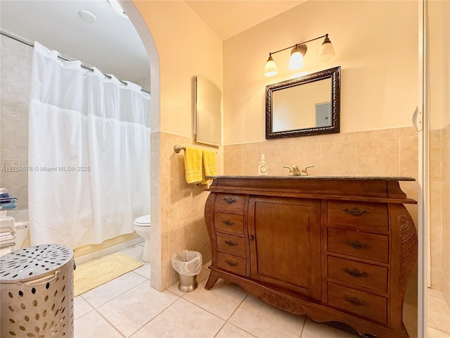 full bath featuring tile patterned flooring, tile walls, vanity, and shower / bathtub combination with curtain