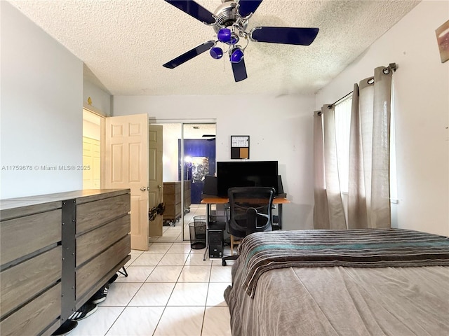 bedroom with light tile patterned floors, a textured ceiling, and a ceiling fan