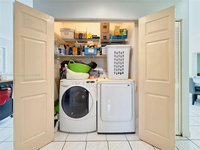 laundry room featuring light tile patterned floors, laundry area, and independent washer and dryer