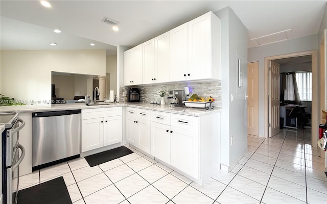 kitchen with a sink, tasteful backsplash, white cabinetry, appliances with stainless steel finishes, and light tile patterned floors