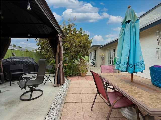 view of patio featuring outdoor dining space, area for grilling, french doors, and fence