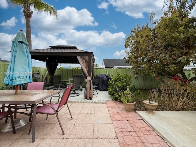 view of patio / terrace with a gazebo, outdoor dining space, area for grilling, and fence