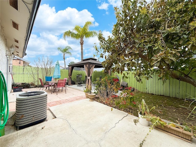 view of patio / terrace featuring a fenced backyard, outdoor dining space, a gazebo, and central AC