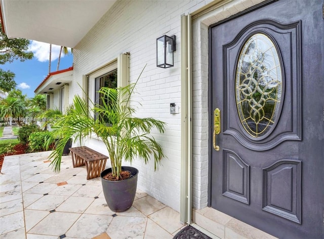 property entrance featuring brick siding and a patio area