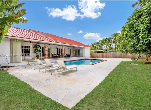 view of swimming pool with a patio, fence, a ceiling fan, a lawn, and a fenced in pool