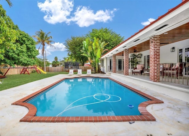 view of pool featuring a fenced in pool, a fenced backyard, ceiling fan, a patio area, and a playground