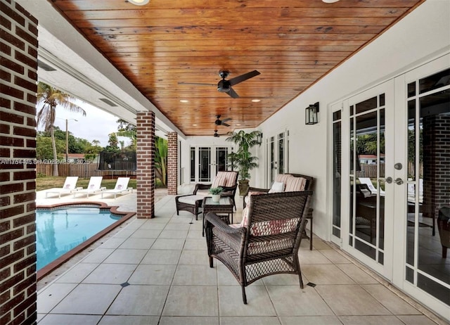 view of patio / terrace with ceiling fan, fence, french doors, a fenced in pool, and a trampoline