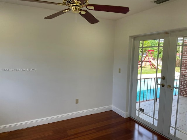 unfurnished room with baseboards, wood finished floors, and french doors