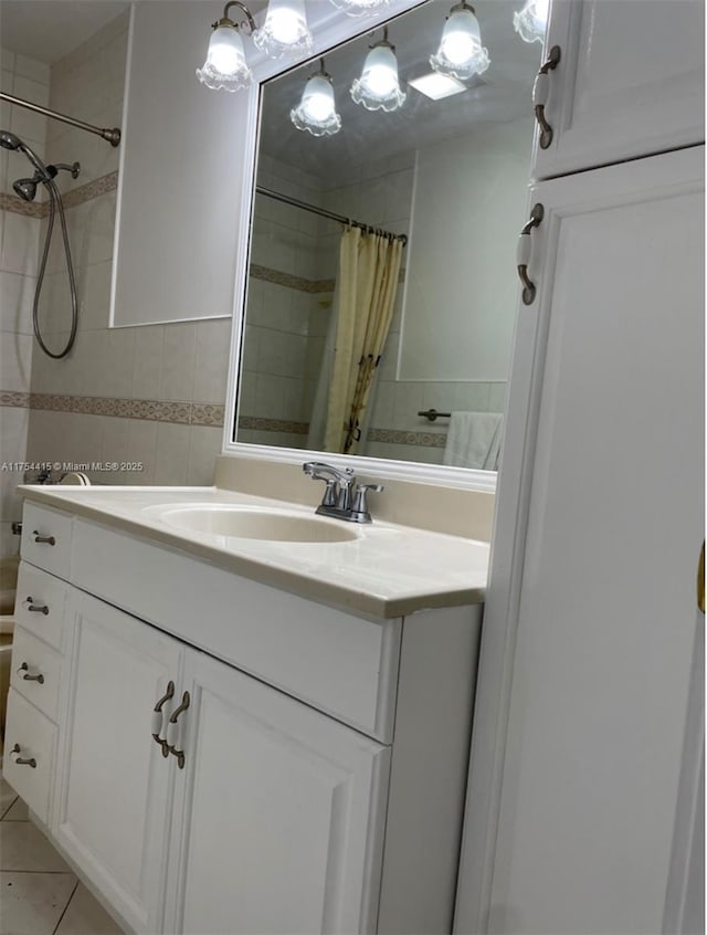 bathroom with vanity, a tile shower, tile walls, and tile patterned floors