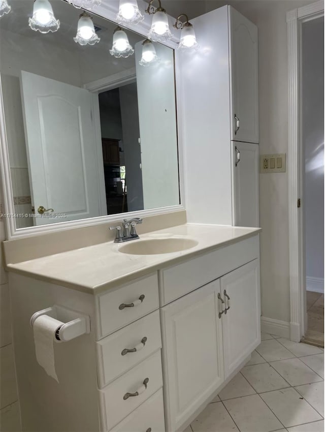 bathroom featuring tile patterned floors, baseboards, and vanity