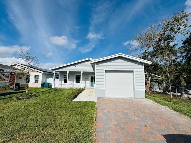 view of front of property with decorative driveway, a front lawn, an attached garage, and fence