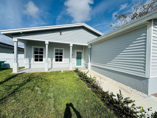 exterior space featuring a lawn, a porch, and fence