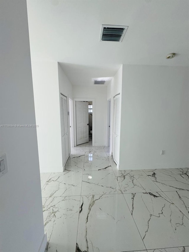 hall with visible vents and marble finish floor