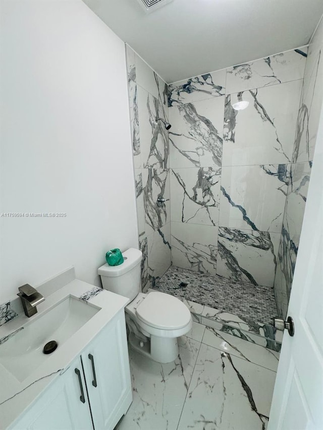 full bath with a marble finish shower, marble finish floor, toilet, and vanity