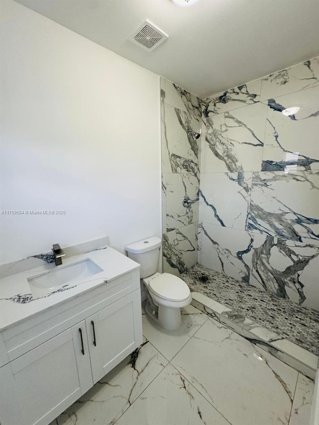 full bath with a marble finish shower, visible vents, toilet, marble finish floor, and vanity