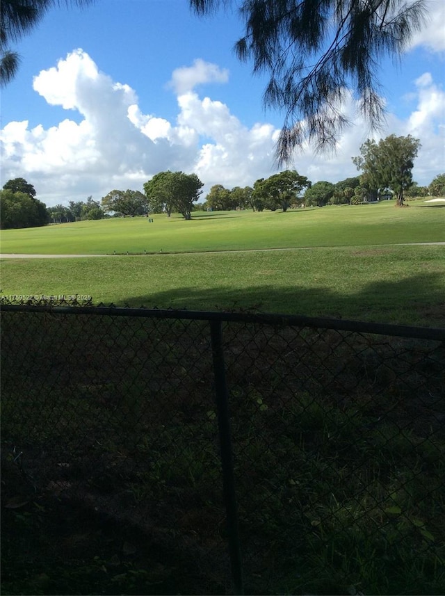 view of home's community featuring view of golf course and a lawn