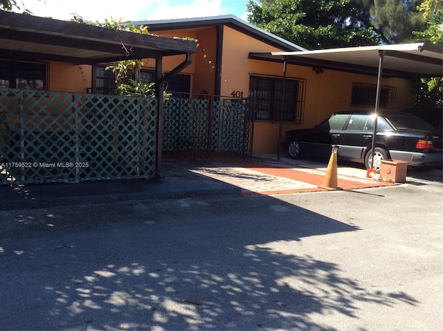 view of vehicle parking featuring a carport and fence