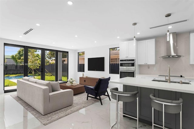 living area with marble finish floor, french doors, visible vents, and recessed lighting