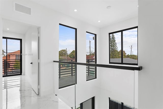 hall with marble finish floor, visible vents, and recessed lighting