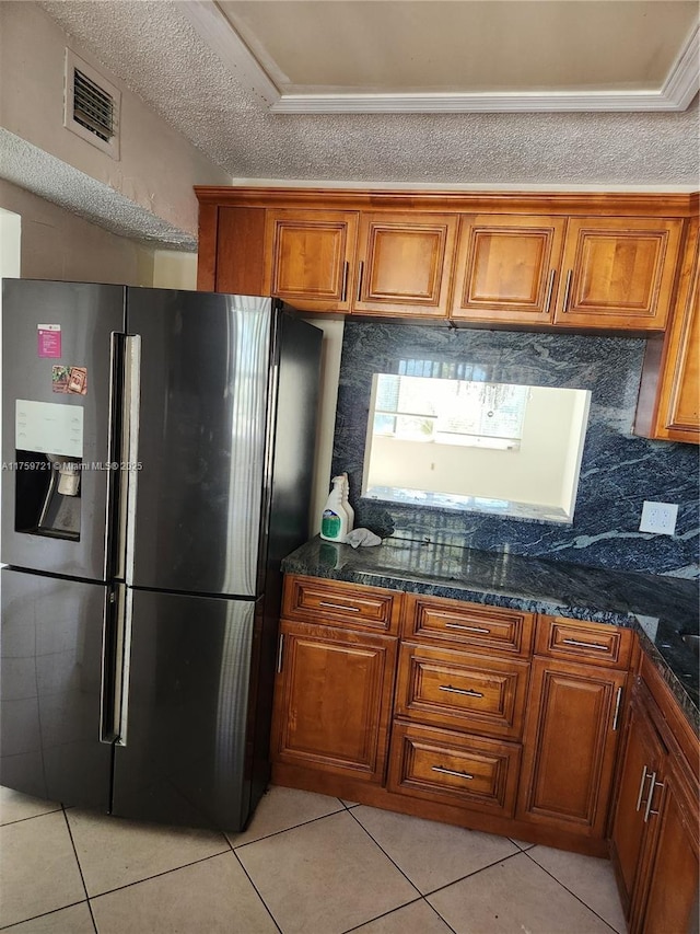 6670 Royal Palm Unit K 202, Pompano Beach, FL 33063 - kitchen featuring refrigerator with ice dispenser, brown cabinetry, light tile patterned flooring, tasteful backsplash, and dark stone counters
