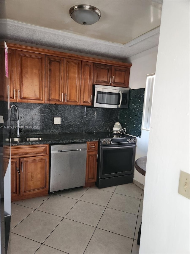 6670 Royal Palm Unit K 202, Pompano Beach, FL 33063 - kitchen with appliances with stainless steel finishes, light tile patterned floors, a sink, tasteful backsplash, and brown cabinetry