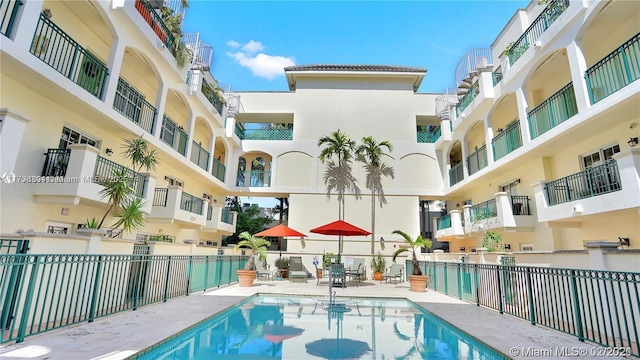 community pool featuring a patio area and fence