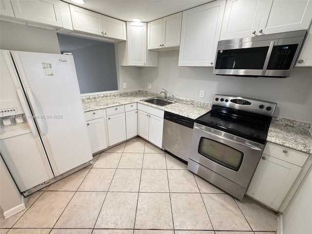 kitchen with light tile patterned floors, white cabinetry, stainless steel appliances, and a sink