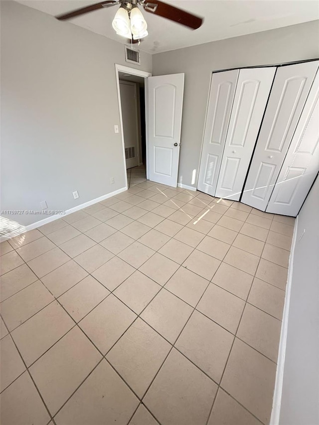 unfurnished bedroom with a closet, visible vents, baseboards, and light tile patterned floors