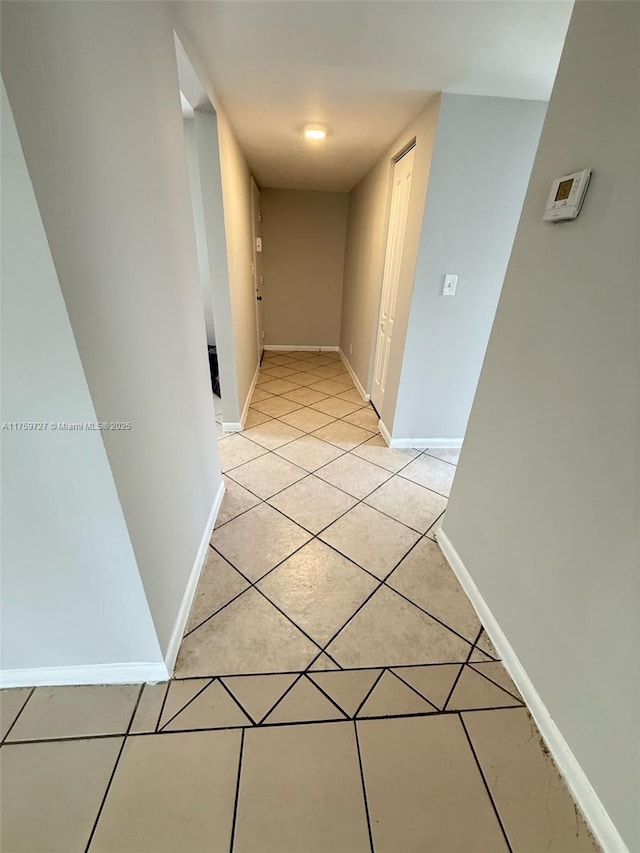 hallway with baseboards and light tile patterned flooring