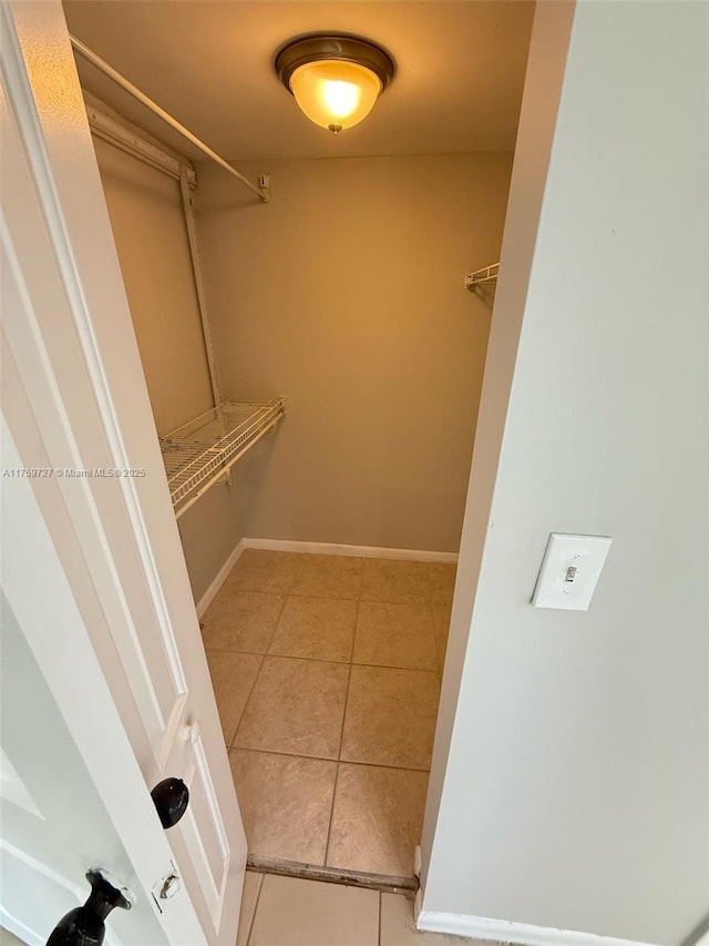 spacious closet with light tile patterned floors