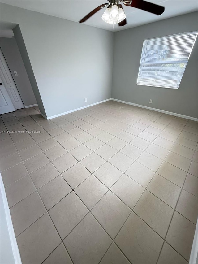 unfurnished room with light tile patterned flooring, ceiling fan, and baseboards