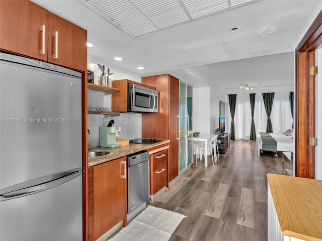 kitchen featuring stainless steel appliances, dark wood-style flooring, brown cabinets, and open shelves