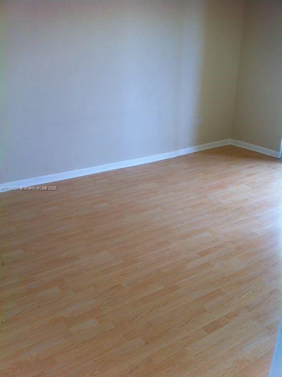 unfurnished room featuring light wood finished floors and baseboards