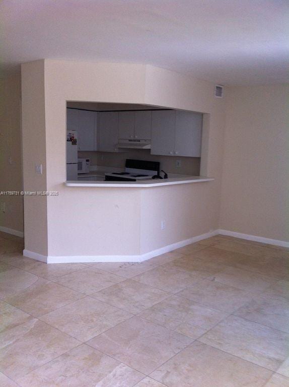 kitchen featuring white electric range oven, under cabinet range hood, light countertops, and freestanding refrigerator