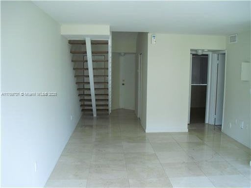 unfurnished room with visible vents