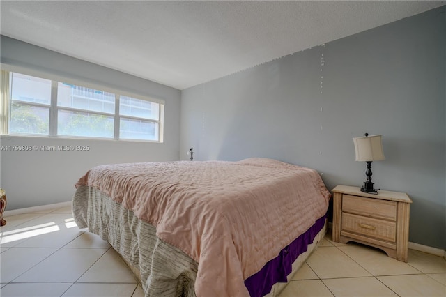 bedroom featuring light tile patterned floors and baseboards