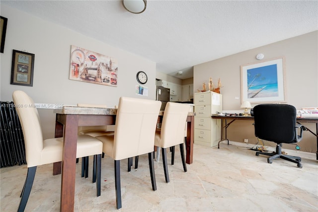 dining room with stone finish flooring and a textured ceiling