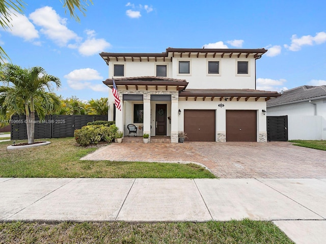 view of front of house featuring fence, a tile roof, stucco siding, decorative driveway, and a garage