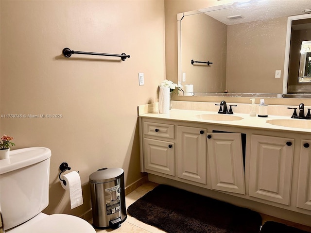 bathroom with toilet, double vanity, visible vents, and a sink