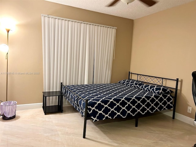 bedroom with a ceiling fan, a textured ceiling, and baseboards