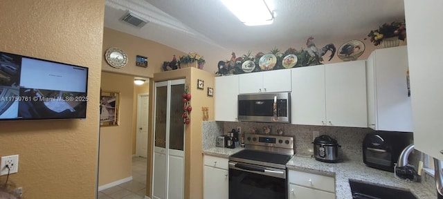 kitchen featuring visible vents, decorative backsplash, appliances with stainless steel finishes, white cabinetry, and a sink