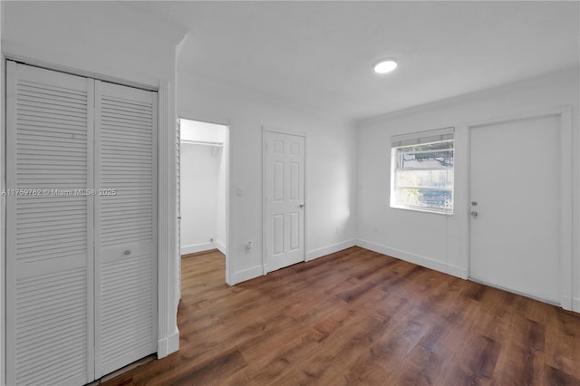 unfurnished bedroom featuring wood finished floors and baseboards