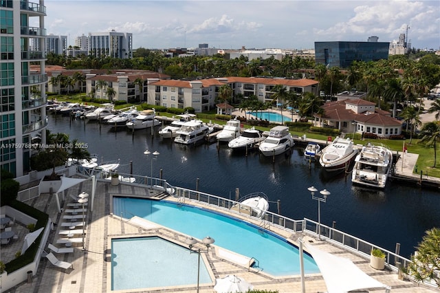 community pool with a water view, a city view, and a patio