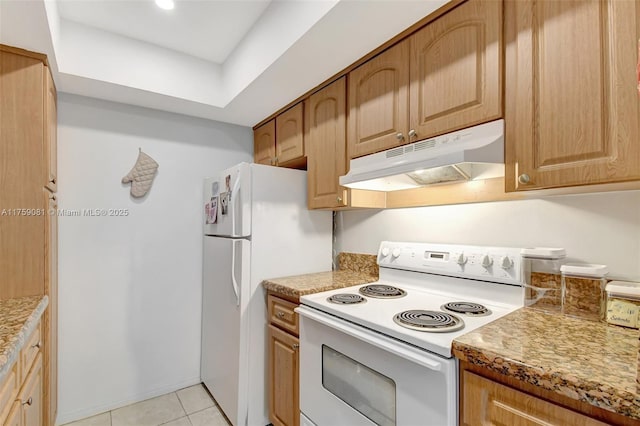 kitchen with white appliances, under cabinet range hood, and light tile patterned flooring