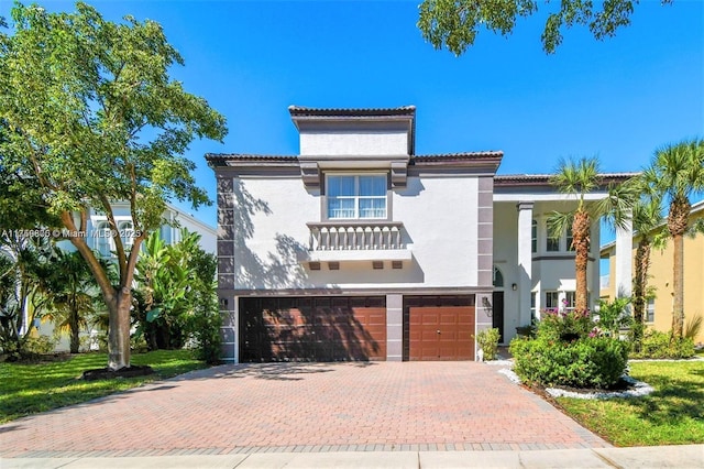 mediterranean / spanish home with an attached garage, decorative driveway, and stucco siding