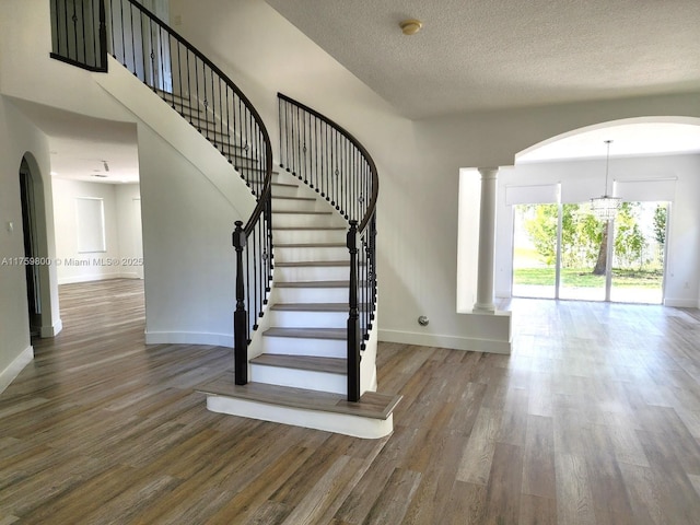 4951 SW 158th Ave, Miramar, FL 33027 - staircase with wood finished floors, arched walkways, a textured ceiling, and decorative columns