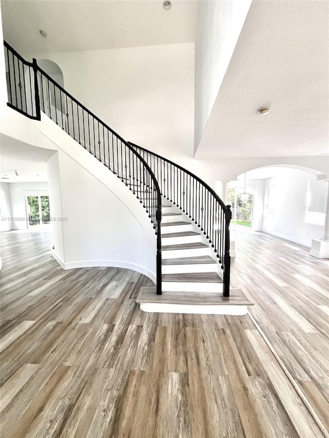 4951 SW 158th Ave, Miramar, FL 33027 - staircase featuring arched walkways, wood finished floors, and a towering ceiling