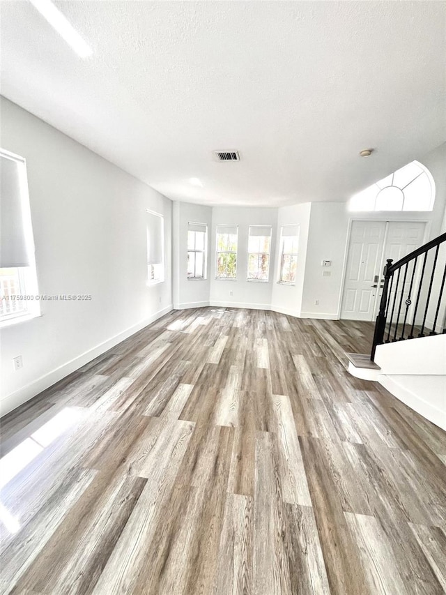 4951 SW 158th Ave, Miramar, FL 33027 - unfurnished living room featuring wood finished floors, stairway, and a textured ceiling