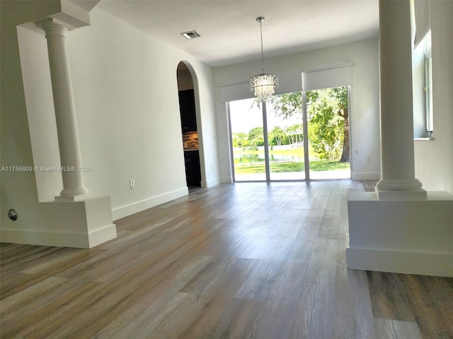 4951 SW 158th Ave, Miramar, FL 33027 - unfurnished living room featuring decorative columns, wood finished floors, arched walkways, and a chandelier