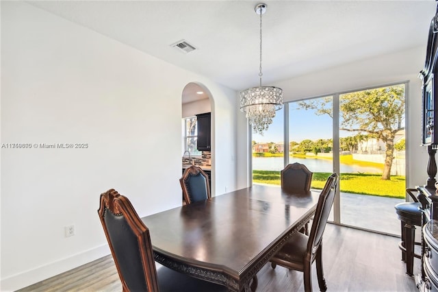 4951 SW 158th Ave, Miramar, FL 33027 - dining room with a chandelier, arched walkways, light wood finished floors, and a water view